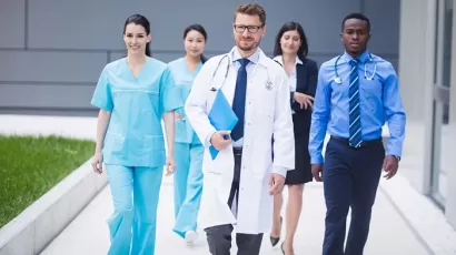 Students in white coats walking on campus