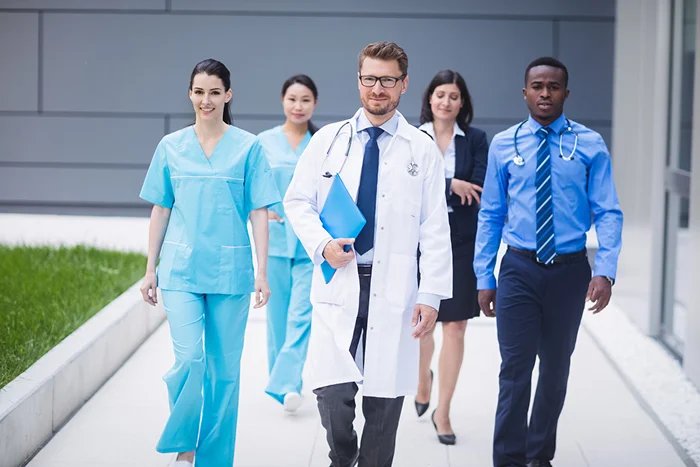 Students in white coats walking on campus